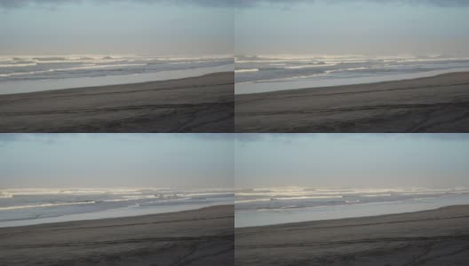 拂晓时分，新西兰穆里韦的小海浪拍打着黑色沙滩高清在线视频素材下载