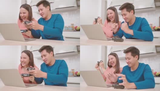 亚洲夫妇使用笔记本电脑，在客厅玩电子游戏。夫妻感到高兴使用时间一起在厨房在家里。高清在线视频素材下载