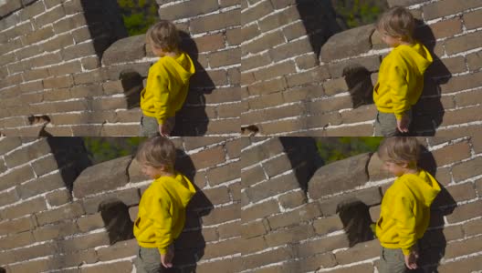 慢动作镜头拍摄的中国长城，上升的一边的山。一位年轻妇女和她的小儿子在长城的楼梯上休息高清在线视频素材下载