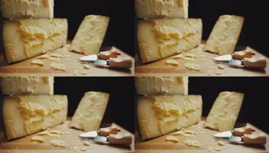 中等硬度的帕尔马干酪头放在木板上，配上帕尔马干酪刀。幻灯片拍摄高清在线视频素材下载