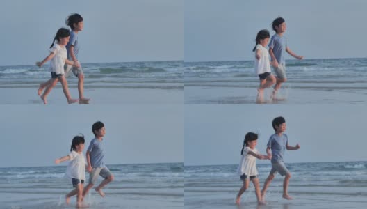 幸福两个4-8岁的亚洲男孩和女孩手牵着手，在海边的沙滩上快乐地奔跑。活跃的孩子户外活动在热带暑假。援助之手的概念。高清在线视频素材下载