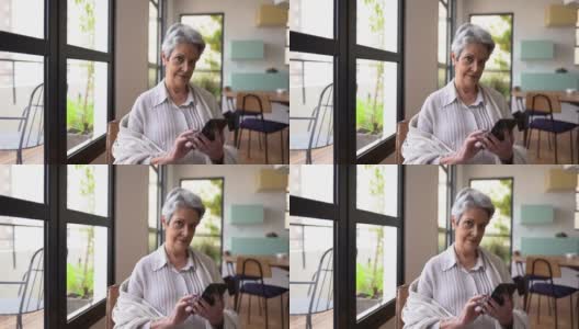 一位年长女性在家里使用智能手机的照片高清在线视频素材下载