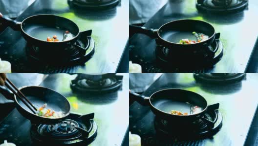 在咖啡馆里，炊具把蔬菜放在黑色的平底锅上做菜高清在线视频素材下载