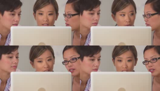 三个亚洲女商人盯着笔记本电脑高清在线视频素材下载