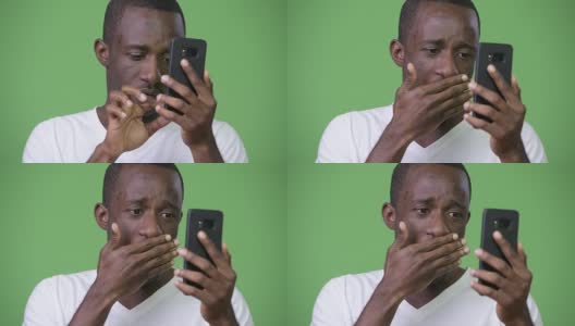 年轻的非洲男子在使用电话时看起来很震惊高清在线视频素材下载