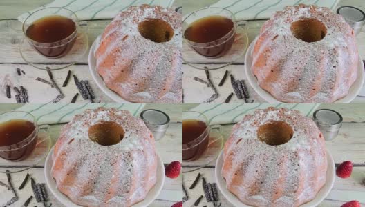 老式的沙蛋糕，一杯红茶和几片香草在木制的背景。蛋黄海绵蛋糕，草莓在乡村白色的背景高清在线视频素材下载