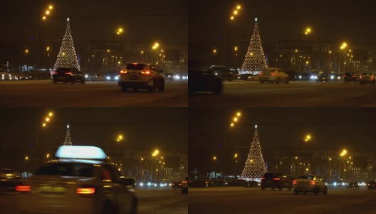 圣诞树在夜晚城市冬天积雪覆盖的道路上闪闪发光，在交通堵塞的车辆中驶过，概念圣诞夜，新年，雪花，吹暴风雪，汽车覆盖的雪，雪花在车灯高清在线视频素材下载