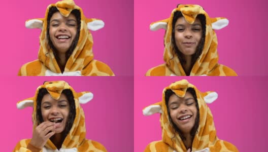 非裔美国女孩穿着长颈鹿睡衣吃爆米花和看喜剧表演高清在线视频素材下载