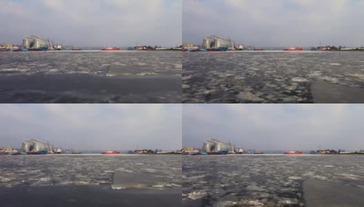 无人机拍摄到货运站的船只、码头上的港口起重机和粮食储存罐正在融冰高清在线视频素材下载