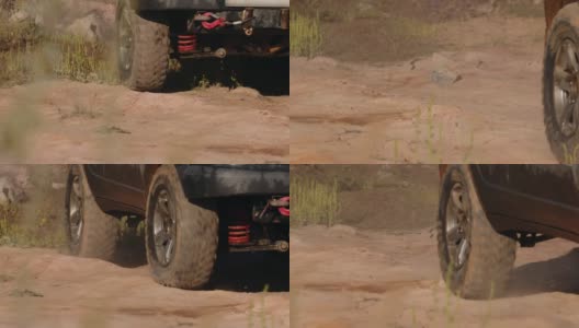 一辆巨大的SUV脏兮兮的车轮正行驶在野外的沙漠路上，特写，俯视。汽车旅行的概念，旅行的欲望高清在线视频素材下载