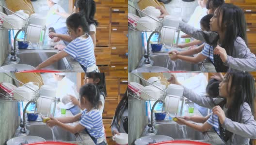 孩子们在学校的厨房里洗碗，孩子们在家里一起帮助做家务高清在线视频素材下载