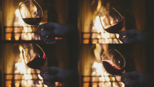 冬天，在壁炉前，斟着红酒，品酒于杯中。高清在线视频素材下载