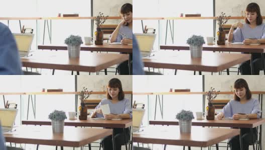 美丽年轻的女学生在咖啡厅看书高清在线视频素材下载