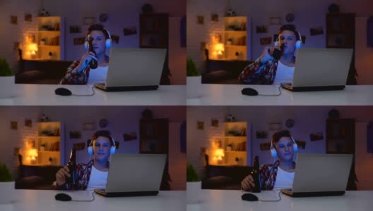 十几岁的男孩在电脑上看电影，喝啤酒，吃零食，浪费时间高清在线视频素材下载