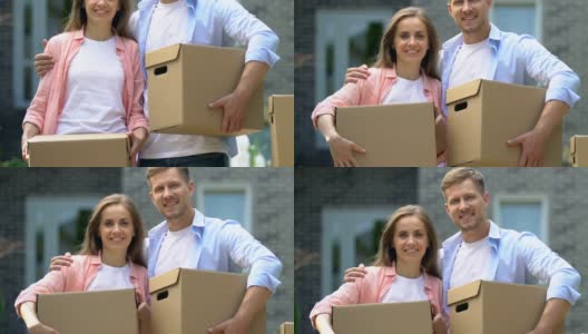白种人丈夫和妻子拿着纸板箱微笑着拍照，搬迁高清在线视频素材下载