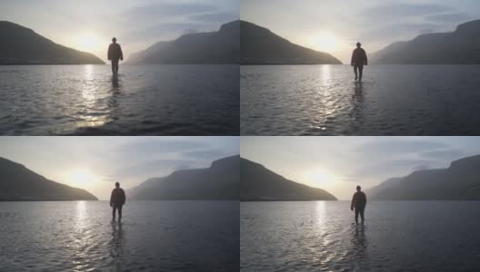 在浅水湖中，人们向日出走去的嗡嗡声高清在线视频素材下载