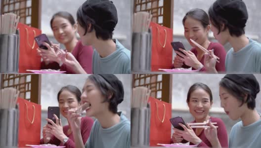 亚洲幸福女人吃饺子和玩手机在户外桌子café。概念时尚女孩的生活方式。高清在线视频素材下载