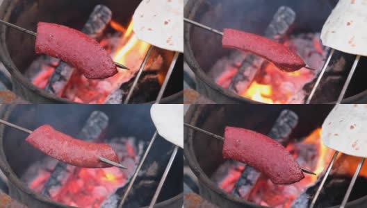 传统的土耳其香肠，SUJUK，放在金属串上，在木火上翻转。高清在线视频素材下载