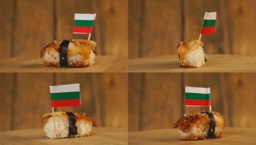 寿司配上鱼、米饭、海藻和保加利亚小旗放在上面，在木制的转盘上旋转。高清在线视频素材下载