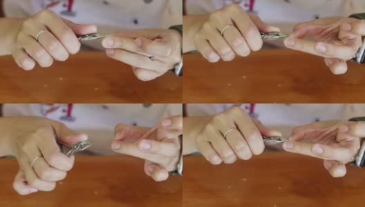亚洲妇女在家里的木桌上用指甲钳剪指甲高清在线视频素材下载
