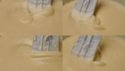 女人们用橡皮刮刀将面粉、鲜奶和鸡蛋搅拌在一起，准备制作自制煎饼的面糊。烹饪过程。高清在线视频素材下载