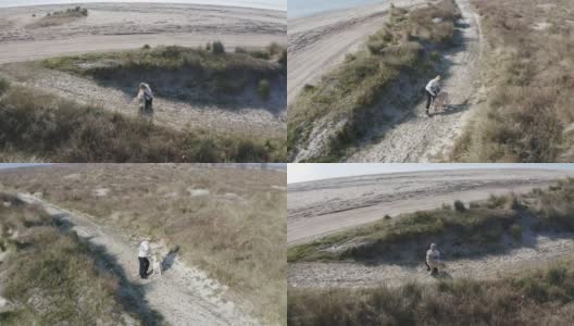 一个年轻的女人和她的狗在海滩上高清在线视频素材下载