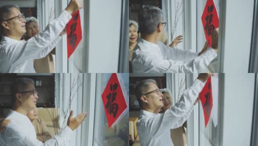 中国新年老夫妇装饰房子的客厅，窗户上的中国书法装饰，准备家庭团聚高清在线视频素材下载