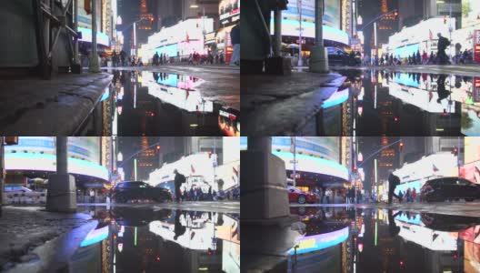 曼哈顿之夜，纽约时报广场的灯光在雨后的水坑中反射高清在线视频素材下载