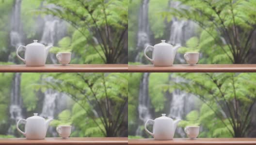 广角拍摄的静物茶具在花园与瀑布的背景高清在线视频素材下载