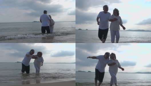 这对浪漫的亚洲老年情侣站在夏日海滩的夕阳下拥抱高清在线视频素材下载
