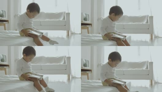 亚洲小男孩在床上看书高清在线视频素材下载