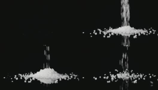 粗糙的海盐晶体落在黑色的背景上高清在线视频素材下载