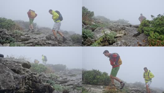 两名男性徒步者在浓雾中沿着一条布满岩石的小径爬上一座山高清在线视频素材下载
