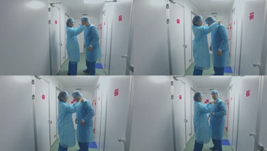 实验室工作人员穿着防护服。穿着实验室大褂的科学家们在走廊里高清在线视频素材下载