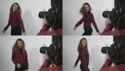 一名年轻漂亮的女学生模特对着数码相机旋转和微笑的慢镜头拍摄了一本女性封面杂志高清在线视频素材下载