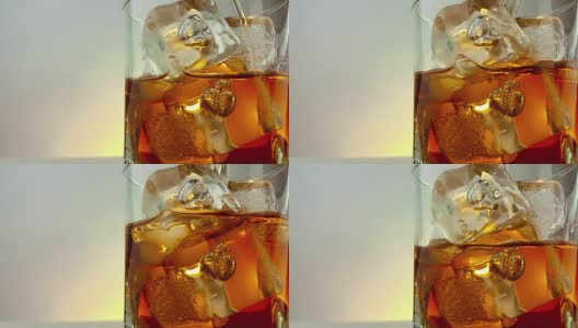 特写的酒保倒威士忌在饮用玻璃与冰块在温暖的白色背景，时间放松喝威士忌高清在线视频素材下载