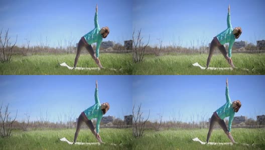 美丽的年轻女子练习瑜伽运动和姿势户外在绿色的草地高清在线视频素材下载