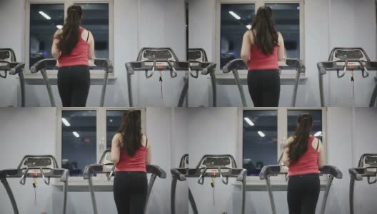 胖女青少年在健身房的跑步机上高清在线视频素材下载