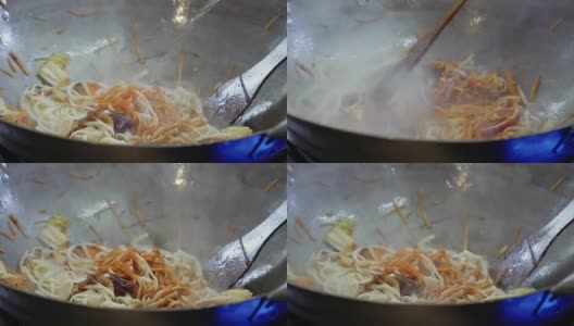 厨师将乌冬面倒入芝麻油，并将其放入热锅中搅拌高清在线视频素材下载