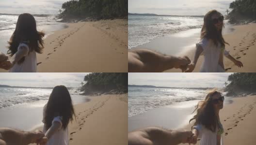 跟着我拍的一个年轻女人拉着她的男朋友在海边。女孩牵着男人的手，在热带异国的海滩上奔向大海。暑假或假期。的观点。观点慢动作高清在线视频素材下载