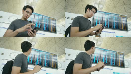 一名亚洲男子在机场盯着登机牌和智能手机高清在线视频素材下载