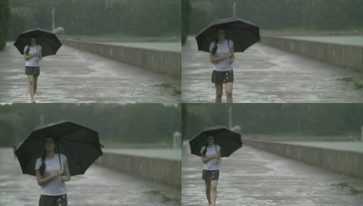 女孩撑着伞在雨天独自走在街上高清在线视频素材下载