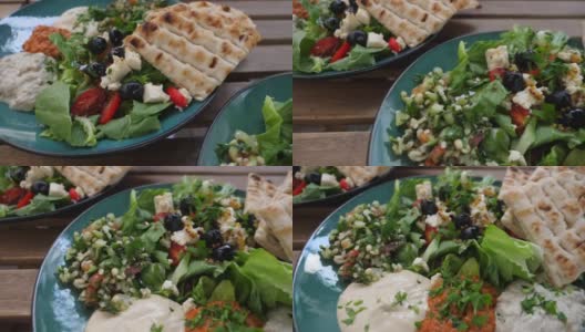 俯视图与meze，沙拉蘸酱和皮塔饼两个盘子。健康的中东有机烹饪高清在线视频素材下载