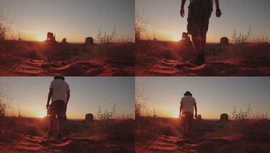犹他州日出时，一个年轻人走在纪念碑谷的沙地上。美国高清在线视频素材下载
