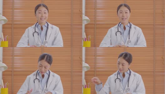 摄像头查看亚洲女医生微笑会与患者在线咨询健康健康生活，智能医生穿着白大褂，带着听诊器视频通话在医院高清在线视频素材下载