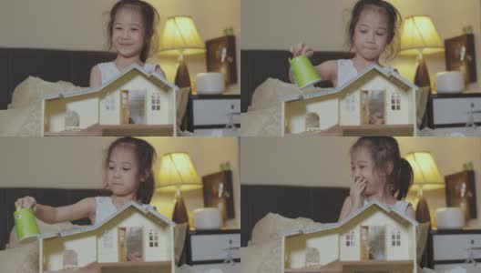 可爱的5岁亚洲女孩是玩具娃娃房，晚上在床上微笑和幸福显示学习和创造力的概念，通过在家的休闲活动。高清在线视频素材下载