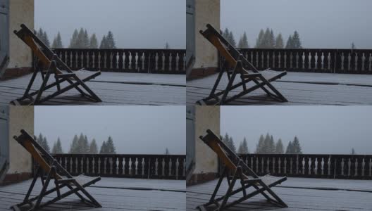 冬天的景观露台木房子和木椅在大雪期间，大雪落在一个郊区社区高清在线视频素材下载