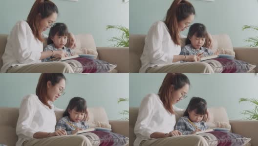 亚洲家庭与女儿做家庭作业与母亲在家里的帮助高清在线视频素材下载