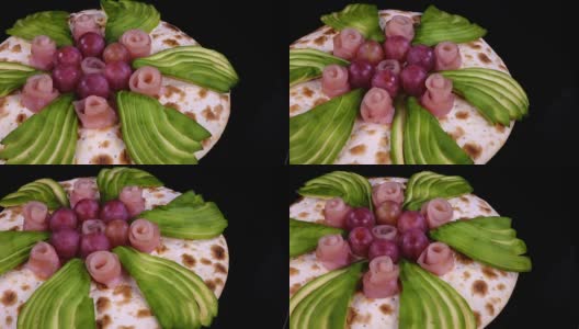 披萨有鳄梨，葡萄和装饰火腿像玫瑰一样旋转高清在线视频素材下载