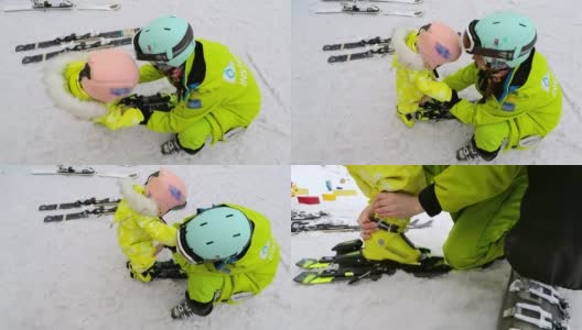 教练帮助给婴儿穿滑雪板。高清在线视频素材下载
